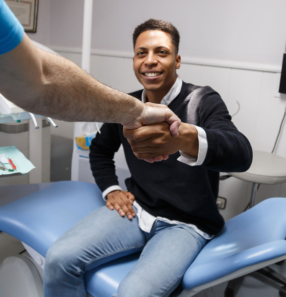 dental patient shaking hands with doctor within the dental center