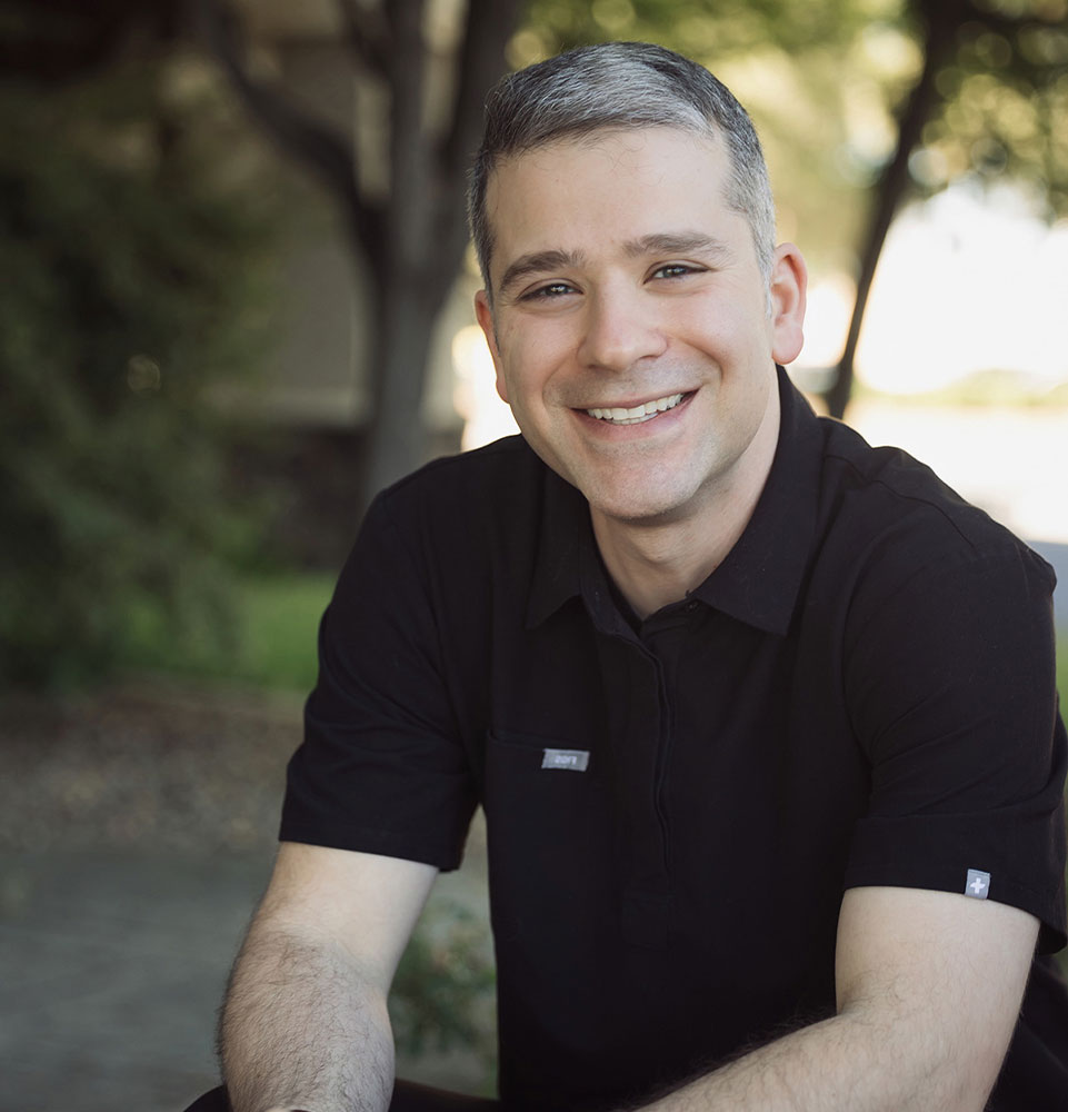 Headshot of doctor smiling outside of the dental center