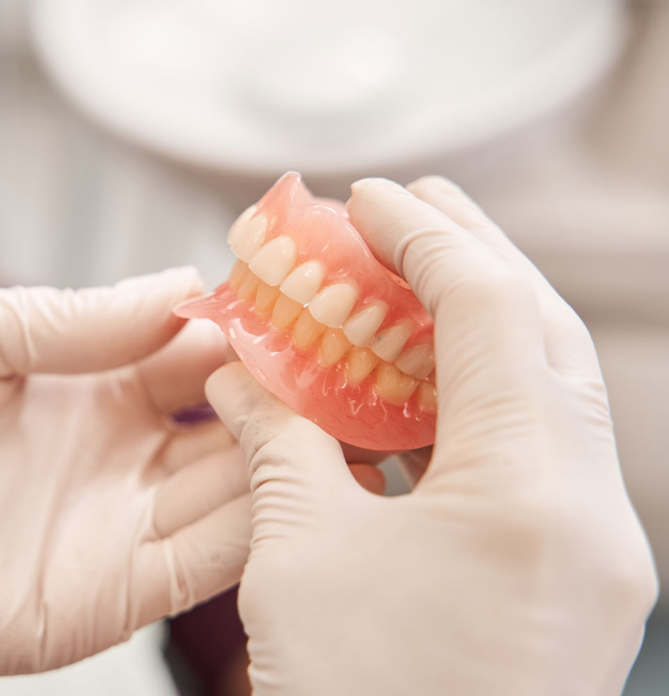 Dentist holding dentures in her hands
