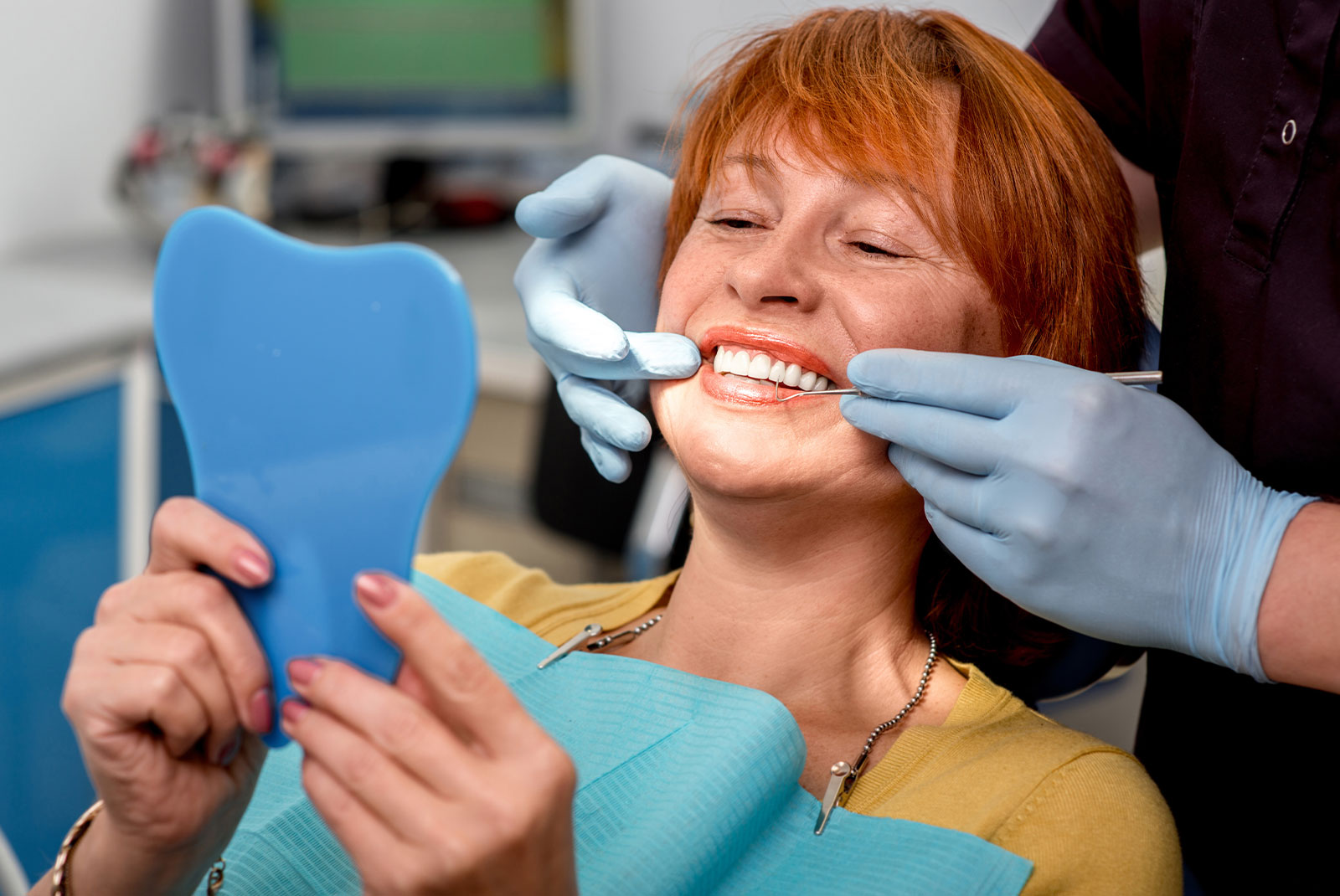 mature women in dental office smiling brightly