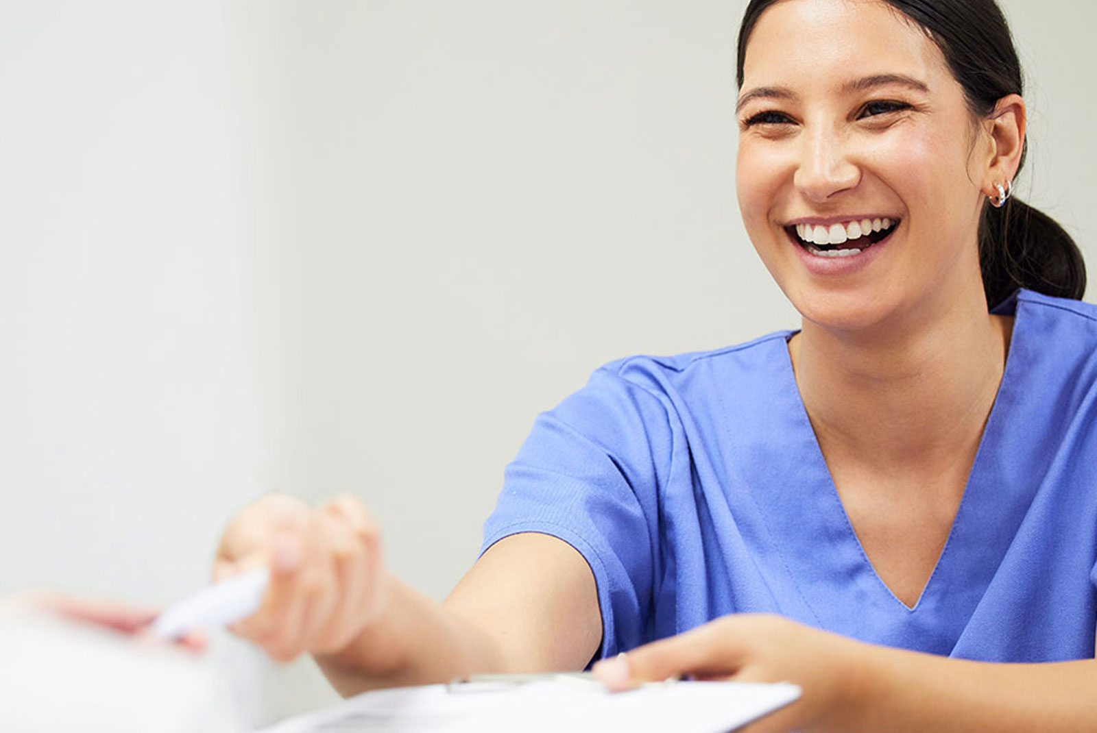 staff member helping at the front desk of the dental office