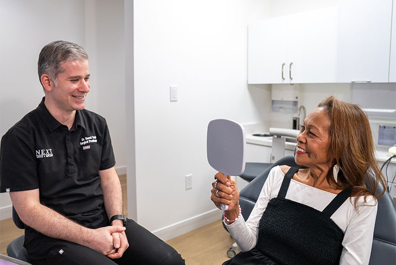 Patient looking into mirror smiling